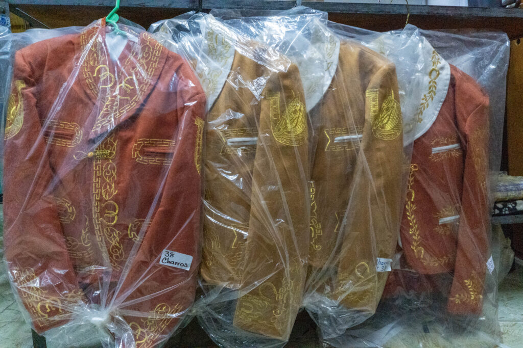 trajes-charro-colgados-sacos-dyrazno-beige-grecas-doradas-fabricante-casa-ortega-bolsa